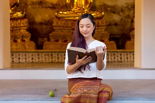 A lady holding a prayer book - How to Create An Effective Prayer - Poh Ern Si Penang Blog